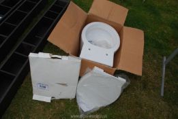 A boxed toilet bowl and seat.