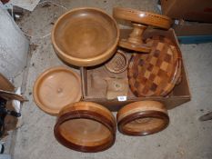 A box of Treen including turned wooden bowls, cake stand and large platter etc.