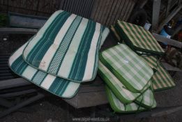 A quantity of garden seat cushions in gingham check.