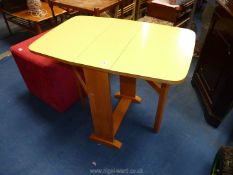 A yellow Formica drop leaf kitchen table.