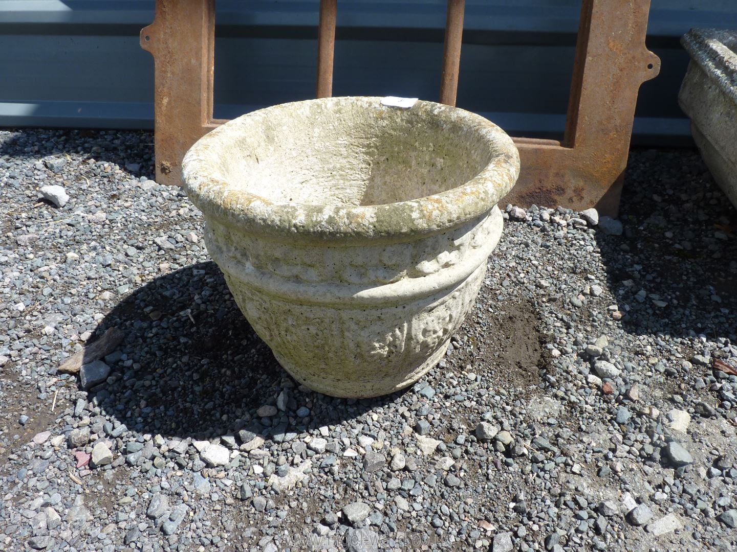 A rounded concrete planter, 13" diameter x 10" high.