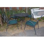 A metal garden table and four chairs with green cushions approx. 35 1/2" (d) x 28".