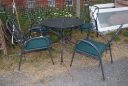 A metal garden table and four chairs with green cushions approx. 35 1/2" (d) x 28".