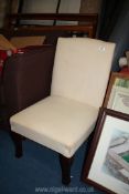 A cream upholstered bedroom chair.