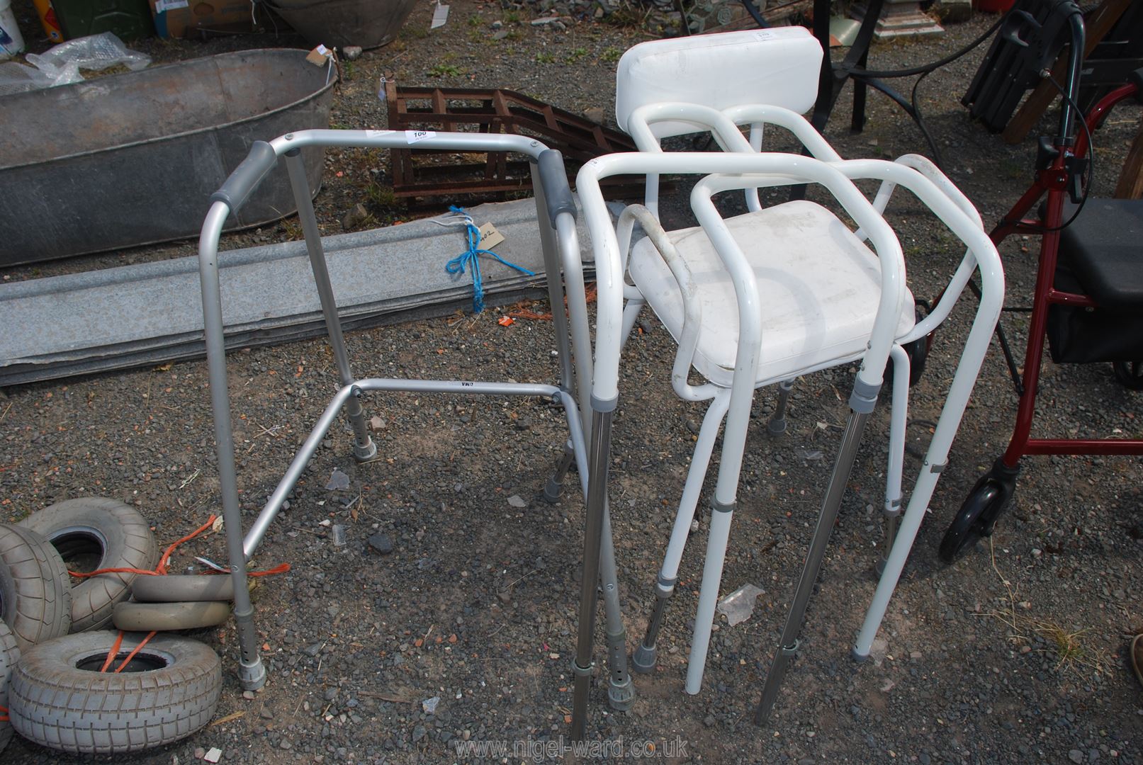 An aluminium zimmer frame with adjustable stool and bed handles.