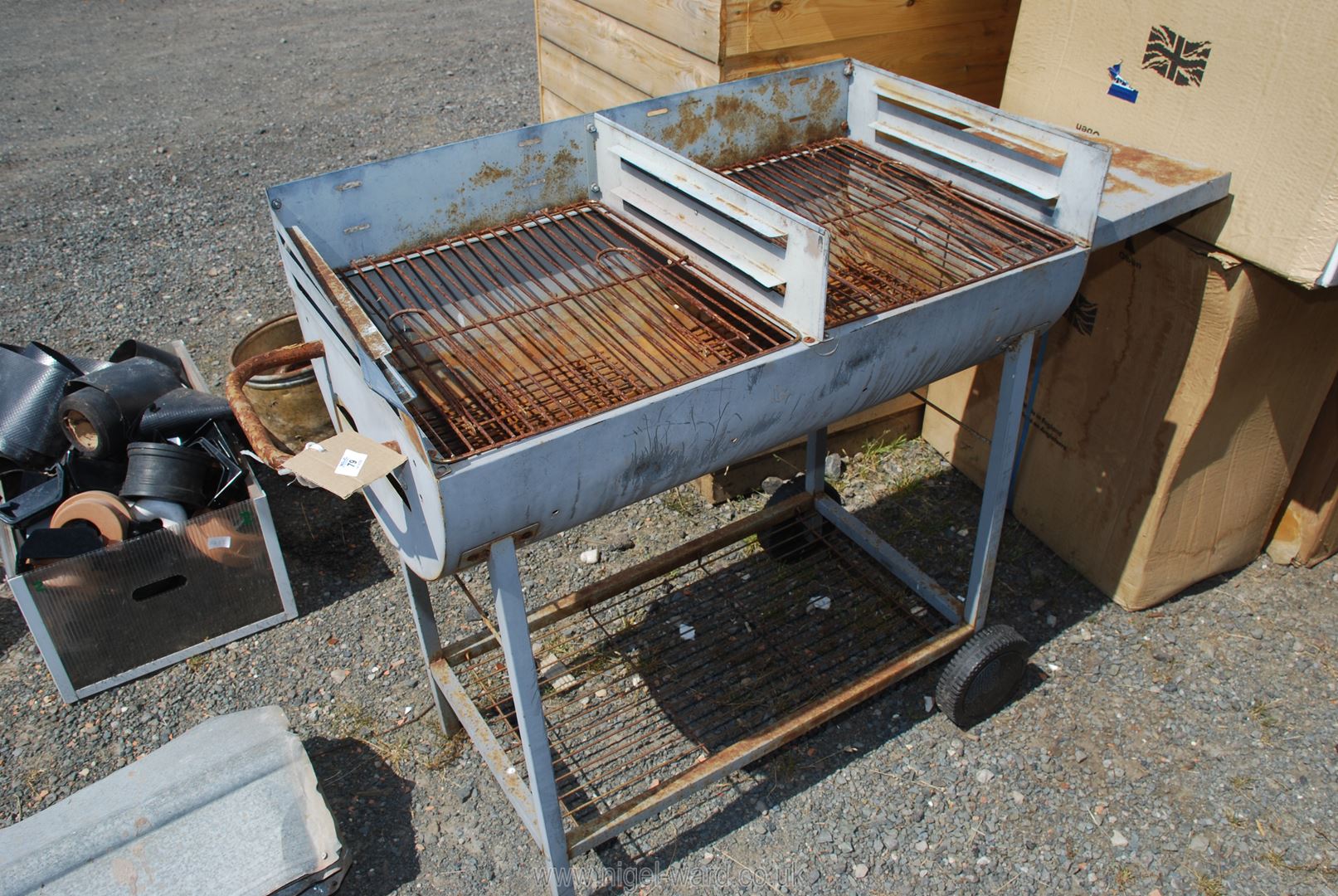 A large barbecue on wheels with double grill.