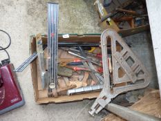 A box containing old tools including a spirit level, chisels, a set square, etc.