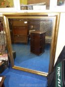 A large gold framed bevelled wall mirror, 35" wide x 46" high.