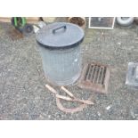 An old metal bin with damaged base and a cast iron boot scraper.