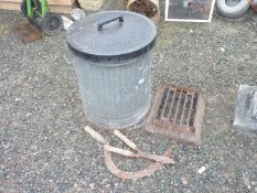 An old metal bin with damaged base and a cast iron boot scraper.