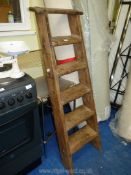 A vintage six-rung wooden ladder.