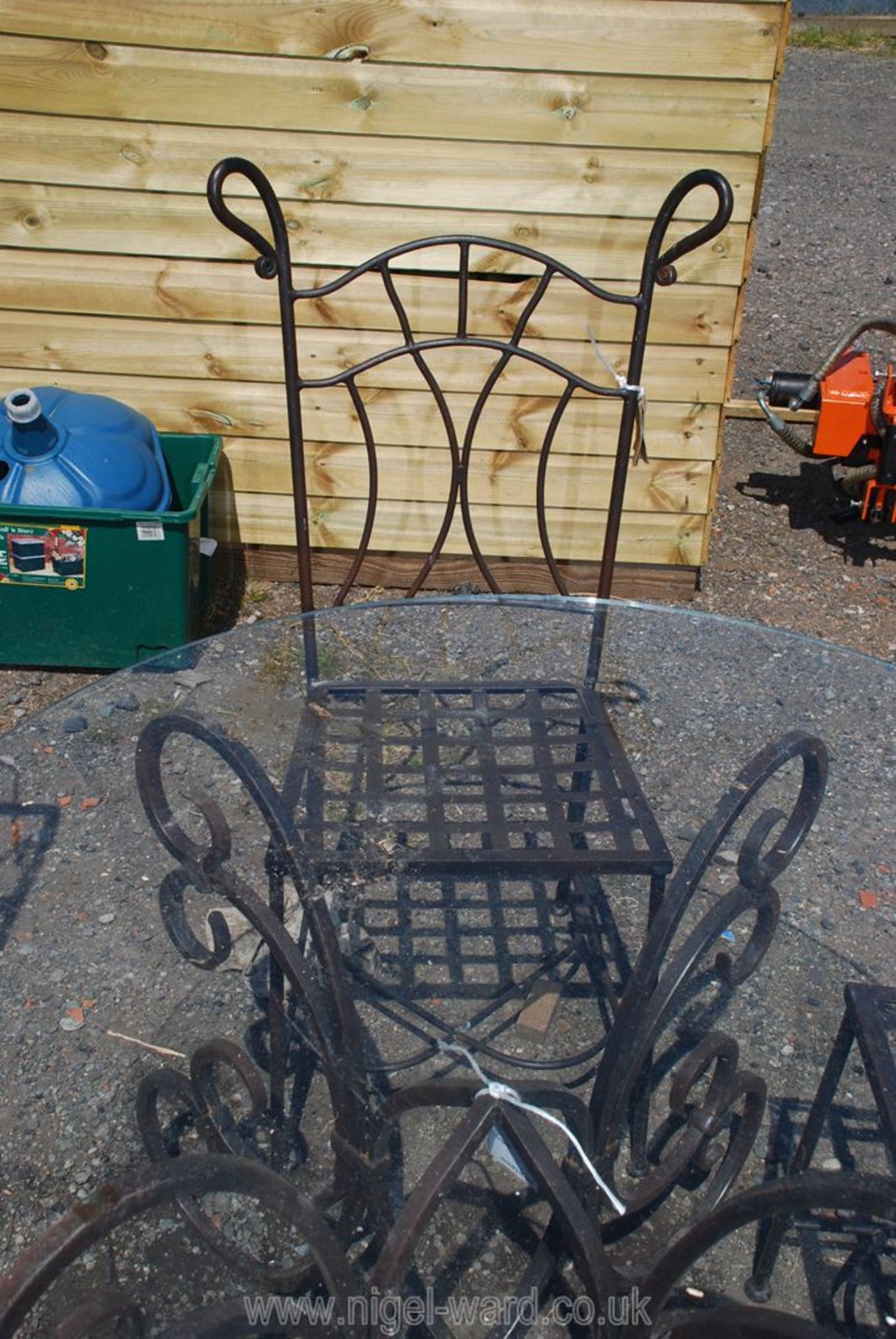 An ornate iron based glass topped table and three chairs, 3' 7 1/2" diameter x 2' 3 1/2" high. - Image 3 of 3