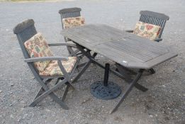 A wooden 'Classic' garden table and 3 chairs with cushions and umbrella stand.