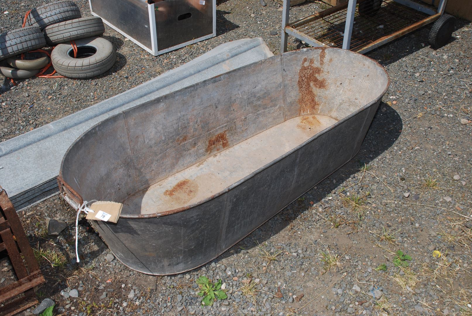 A galvanised bath with handles (hole in base.