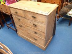 Stripped pine chest of 2 short over 3 long drawers with swan neck drop handles, one missing,