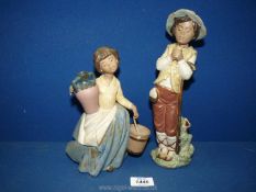 Two matt finish Nao figurines including a boy holding a bird (repaired) and a girl carrying a