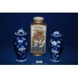 Two lidded oriental vases in blue & white with prunus blossom motif having two blue circles to base,