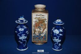 Two lidded oriental vases in blue & white with prunus blossom motif having two blue circles to base,