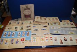 A box of cigarette cards in albums, themes to include cricketers, dogs, RAF badges etc.