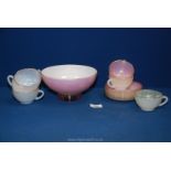 A pink glass bowl with white interior and six Arcopal cups and saucers.