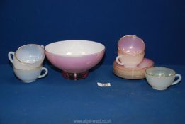 A pink glass bowl with white interior and six Arcopal cups and saucers.