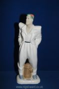 An Art Deco continental porcelain figurine of a stylish youth astride a water hydrant.