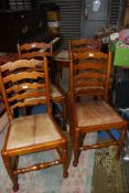 A set of four Oak framed ladder back Dining Chair having turned front legs terminating in pad feet