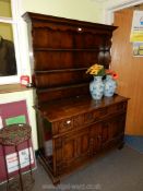 A Reproduction Oak Dresser with two drawers, two door cupboard below and having carved detail.