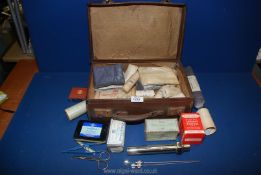 A small suitcase and contents of vintage bandages and First Aid items.