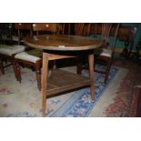 An Oak Cricket Table, the legs united by a lower shelf, 30'' diameter,