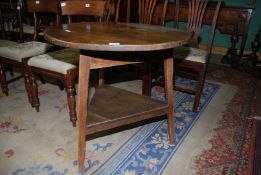 An Oak Cricket Table, the legs united by a lower shelf, 30'' diameter,