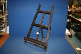 A table top easel, (adjustment pegs absent), 25'' high x 14'' at widest point.