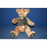 A jointed Harrod's Teddy Bear in light brown with green waistcoat, 20'' tall.