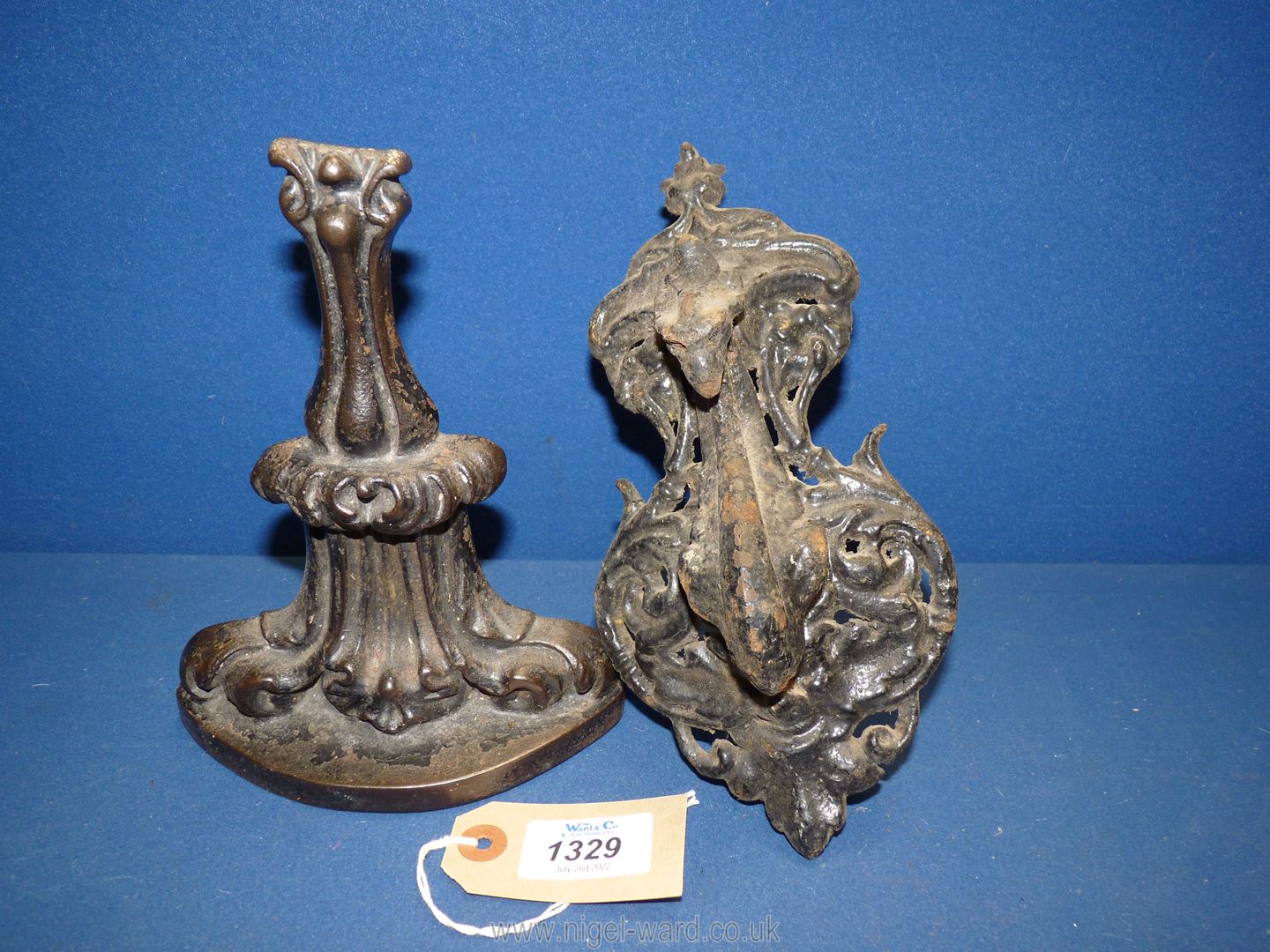 A cast iron door knocker having a peacock head and a cast iron door stop.