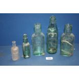 Five glass bottles in varying sizes including Arnold Perrett and Co.