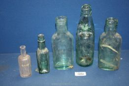 Five glass bottles in varying sizes including Arnold Perrett and Co.