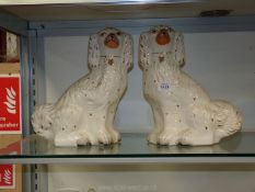 A pair of white Mantle Spaniels with gold padlocks, 12 3/4" tall.