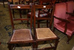 A pair of cane seated darkwood bedroom chairs having light and darkwood stringing.