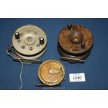 Two Victorian wooden fishing reels and one other.