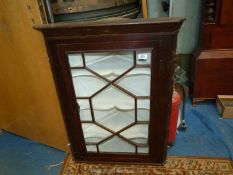 A dark Oak wall hanging Corner Cabinet having a 13 pane geometrically glazed door,