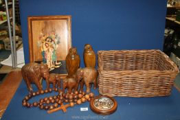 A quantity of wooden items in wicker basket including clown picture, graduated elephants,