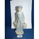 A Lladro figure of a Dutch boy with pails of milk, 8 1/2" tall, repair to one bucket.