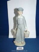 A Lladro figure of a Dutch boy with pails of milk, 8 1/2" tall, repair to one bucket.