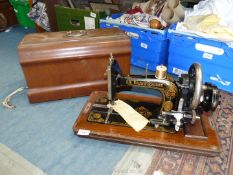 A Frister & Rossmann manual sewing machine having floral decoration, including wooden case,