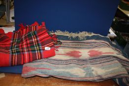 A red wool travel throw and a blue Aztec pattern rug a/f.