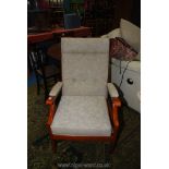 A golden coloured wood framed open armed fireside chair upholstered in pale beige.