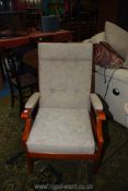 A golden coloured wood framed open armed fireside chair upholstered in pale beige.