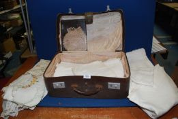 An old vanity suitcase and contents of vintage linen including embroidered, lace edged etc.