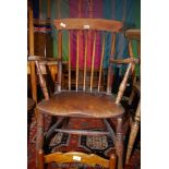 A traditional solid Elm seated kitchen carver chair having stickback turned legs and 'H' stretchers.