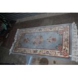 A Kayam fringed rug in oriental floral pattern, blue ground and cream border, 60 1/2" x 31".